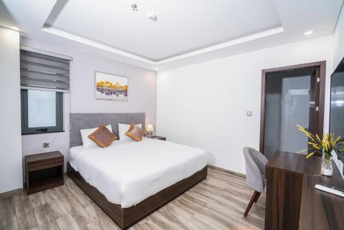 a bedroom with a bed and a desk and a television at SWEDEN HOTEL and APARTMENT in Da Nang