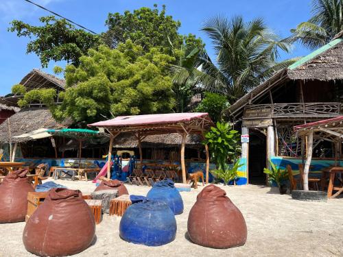 a group of bags sitting in the sand in front of a building at Bamboo Nest Beachfront Floating Tent in Puerto Princesa City
