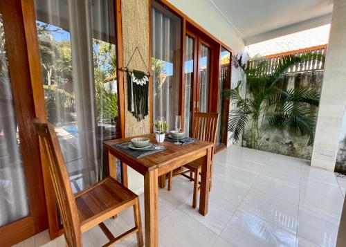 a balcony with a wooden table and a chair at Villa Majegau 2 by Deasha in Seminyak