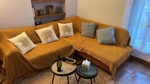 a couch with pillows on it in a living room at Historical center 3 st house, garage & tropeziene in Pézenas