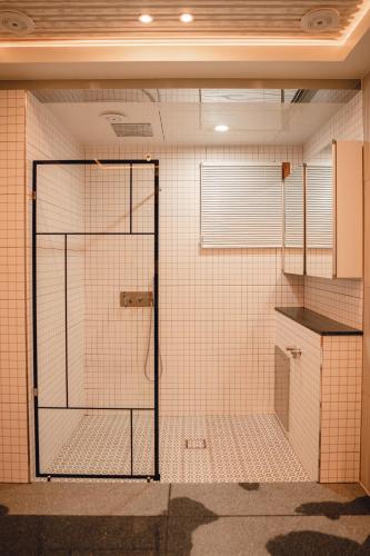 a bathroom with a shower with a glass door at Gyeong-ju Stayangim in Gyeongju
