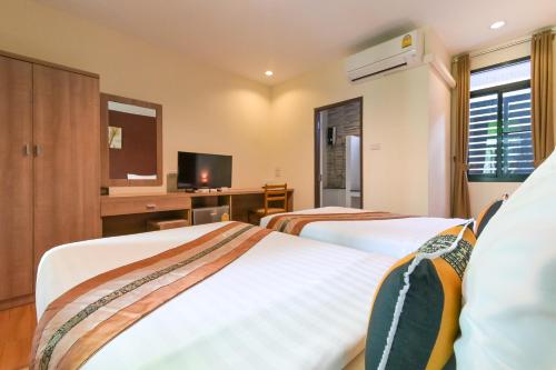 a hotel room with two beds and a tv at Baan Kieng Tawan in Khong Chiam