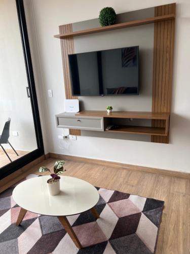 a living room with a table and a tv at Ed Hassler #307 Mariale’s in Asuncion
