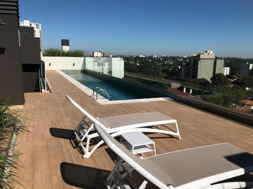 a balcony with chairs and a pool on a building at Ed Hassler #307 Mariale’s in Asuncion