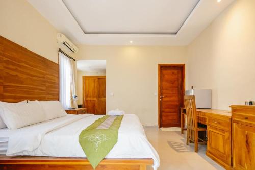 a bedroom with a bed and a desk in it at Dinar Hills Ungasan in Nusa Dua