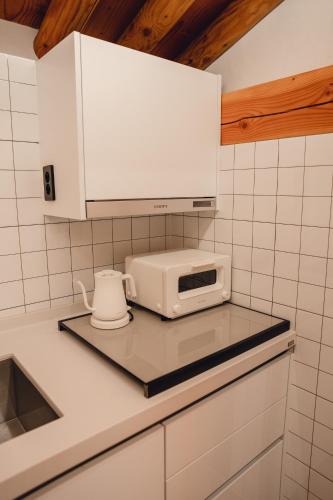 a kitchen with a microwave and a toaster on a counter at Gyeong-ju Stayangim in Gyeongju