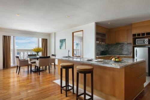 a kitchen with a counter and a dining room at Tower Club at lebua in Bangkok