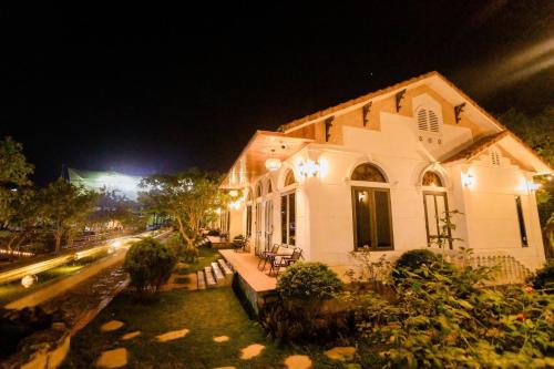 a white house with lights on a street at night at Hoa Lu Garden Resort in Ninh Binh