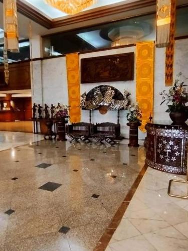 a lobby with benches and a painting on the wall at Lampang Wieangthong in Lampang