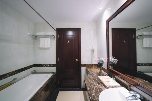 baño con bañera y espejo grande en Saigon Dalat Hotel, en Da Lat