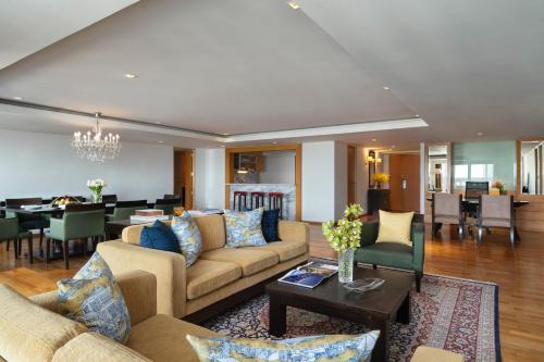 a living room with couches and a dining room at Tower Club at lebua in Bangkok