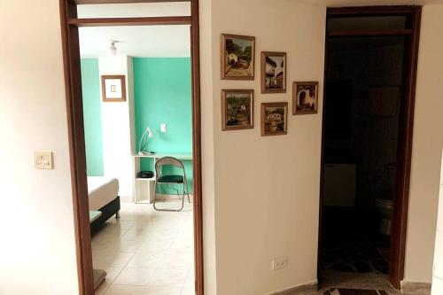 un couloir avec un miroir et une chambre avec un lit dans l'établissement Bonito apartamento con excelente ubicación, à Manizales