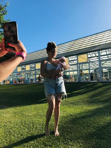 une femme tenant un bébé devant un bâtiment dans l'établissement Mirador, à Federación