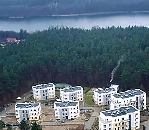 una vista aerea di un gruppo di edifici bianchi di Apartament Longinówka a Brodnica