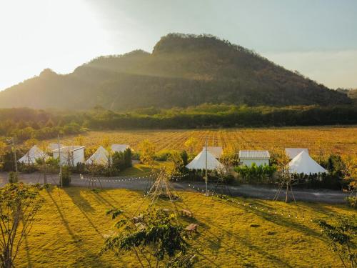 a field with tents and a mountain in the background at Chavallee Campground in Ban Tha Chang