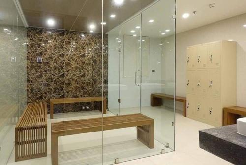 a bathroom with a glass shower with a bench at The Star Hill Chiang Mai in Chiang Mai