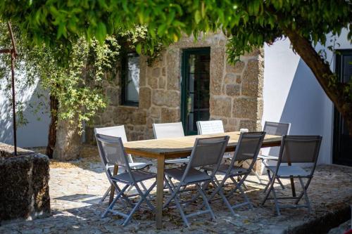 a wooden table and chairs under a tree at The Big House-grand comfort at Serra da Estrella in Gouveia