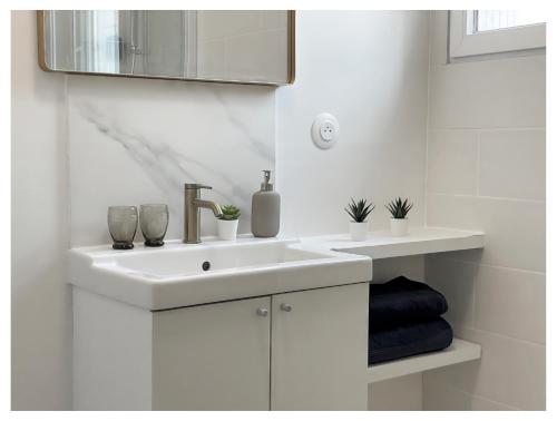 une salle de bain blanche avec un lavabo et un miroir dans l'établissement Sauna & Détente - Suite Privée - Tours - Netflix, à Tours