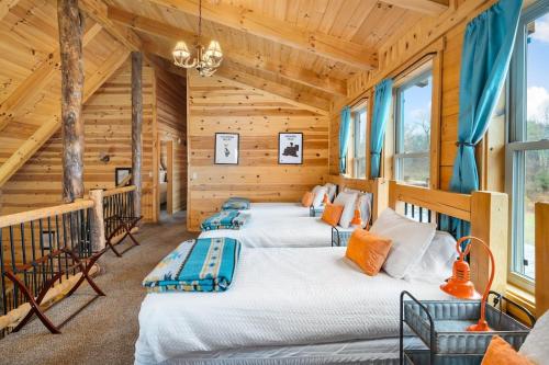 2 camas en una habitación con paredes y ventanas de madera en The Lookout, en Logan
