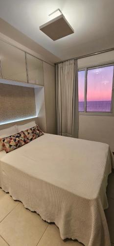 a bedroom with a bed with a view of the ocean at Vista para a Orla de VV in Vila Velha