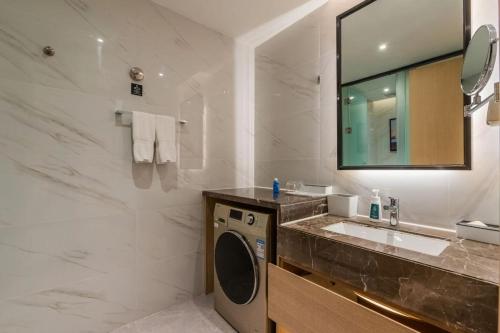 a bathroom with a sink and a washing machine at Atour Hotel (Wuxi Berkesy) in Wuxi