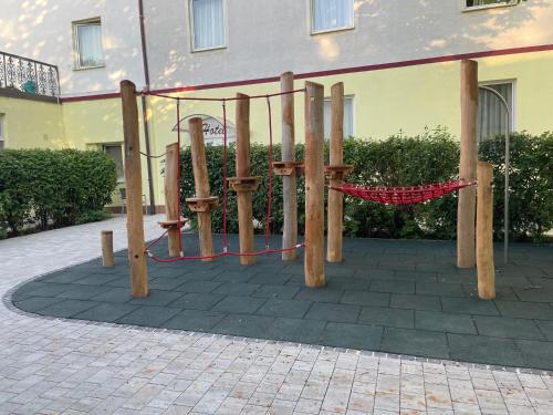 a playground in front of a building with a red rope at Gasthof Roderich Hotel in Langenzersdorf