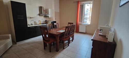 a kitchen with a wooden table and chairs in it at Guest House Italy 21 -Affittacamere in Sassari