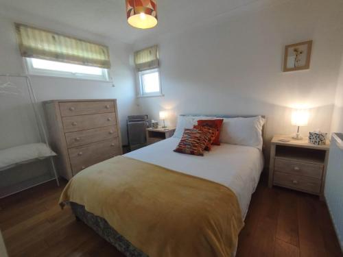 a bedroom with a bed with two night stands and two lamps at Top of the House in Bognor Regis