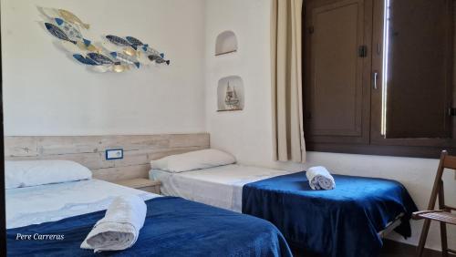 um quarto com duas camas com toalhas em Acacies 25 em Torroella de Montgrí