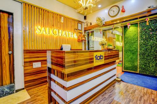 ナーシクにあるFabHotel Sai Chatraの壁掛け時計のあるレストランのバー