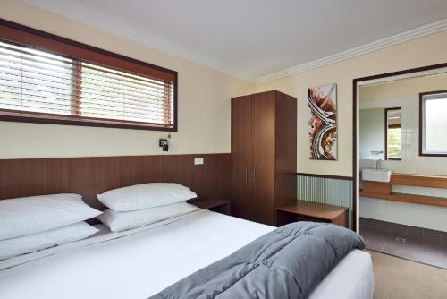 a bedroom with a large bed and a mirror at NRMA South West Rocks Holiday Park in South West Rocks
