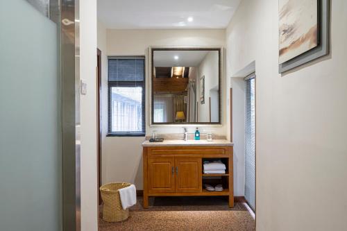 ein Badezimmer mit Waschbecken und Spiegel in der Unterkunft Guilin Crystal Crescent Moon Hotel in Guilin
