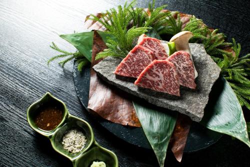a plate of food with slices of watermelon and leaves at Hacho no Yu in Nikko