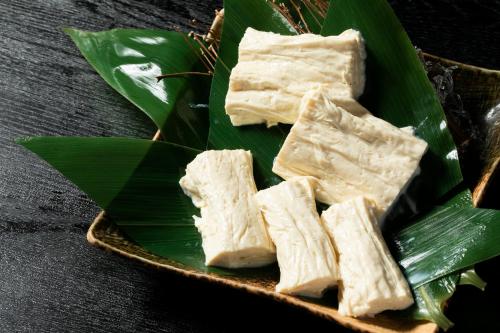 a plate of tofu on a green leaf at Hacho no Yu in Nikko