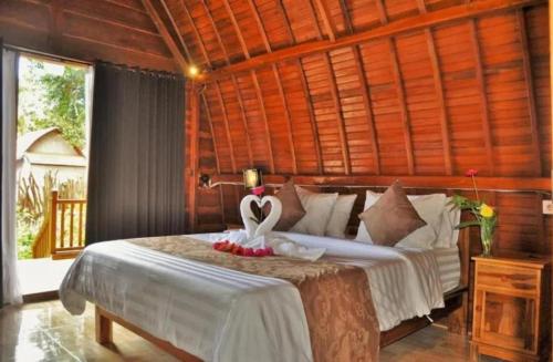 een slaapkamer met een bed met een hart erop bij The Peace Arta Bungalow in Nusa Penida