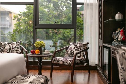 a room with two chairs and a table and a window at Salute Premium Hotel & Spa in Hanoi