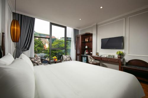 a bedroom with a large white bed and a television at Salute Premium Hotel & Spa in Hanoi