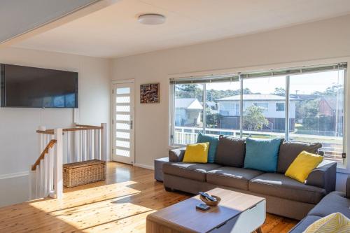 a living room with a couch and a tv at Bright and Breezy in Sussex inlet