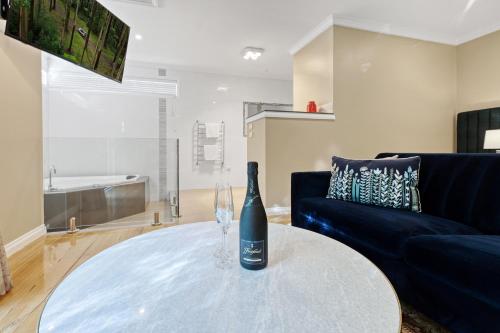 una bottiglia di vino seduta su un tavolo in soggiorno di Wrenfield Cottages a Marysville