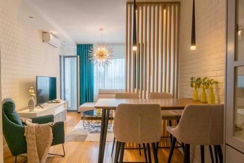 ein Esszimmer und ein Wohnzimmer mit einem Tisch und Stühlen in der Unterkunft Platinum_Luxury_Apartment II in Teslić