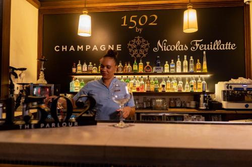 a man standing behind a bar with a wine glass at STORY Seychelles in Beau Vallon