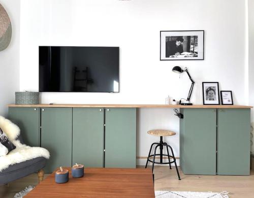 a living room with a tv on top of a cabinet at Le Simone: Appartement de charme coeur de village, 2 chambres in Villard-de-Lans