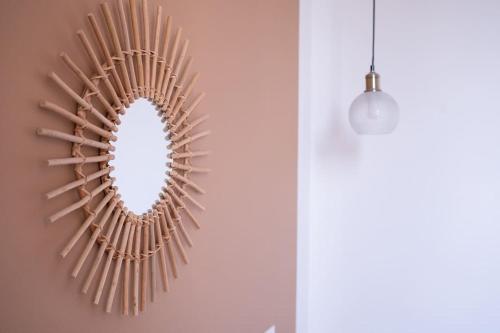 a mirror hanging on a wall next to a lamp at Le Simone: Appartement de charme coeur de village, 2 chambres in Villard-de-Lans