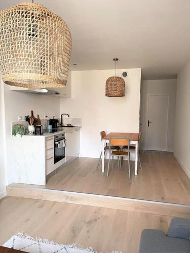 a kitchen and dining room with a table and chairs at Le Simone: Appartement de charme coeur de village, 2 chambres in Villard-de-Lans