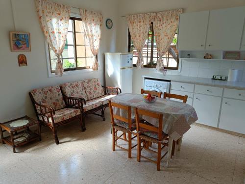 cocina con mesa, sillas y sofá en The Grapevine Guest House, en Pafos