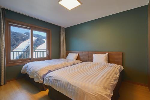 a bedroom with two beds next to a window at Vivaldi Park in Hongcheon