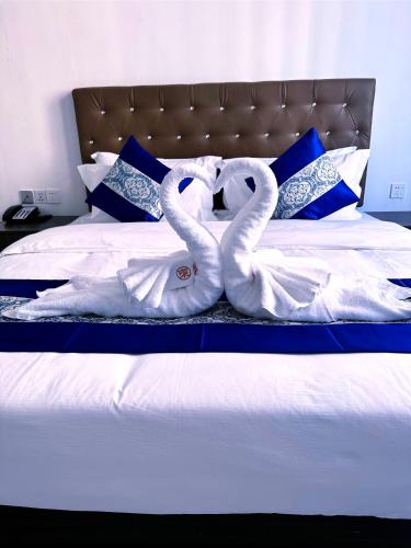two swansuitsrendered to look like they are kissing on a bed at 东方酒店 in Sihanoukville