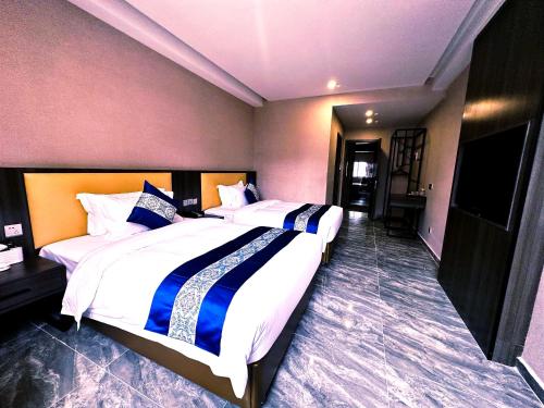 a hotel room with two beds and a flat screen tv at 东方酒店 in Sihanoukville
