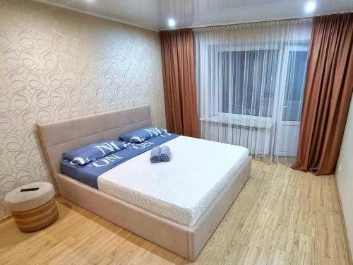 ein Schlafzimmer mit einem großen Bett und einem Fenster in der Unterkunft Yanko in Kökschetau