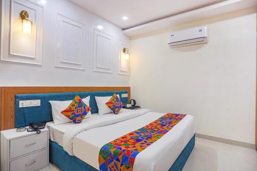 a bedroom with a bed with a colorful blanket at FabHotel Cosmos in Allahābād